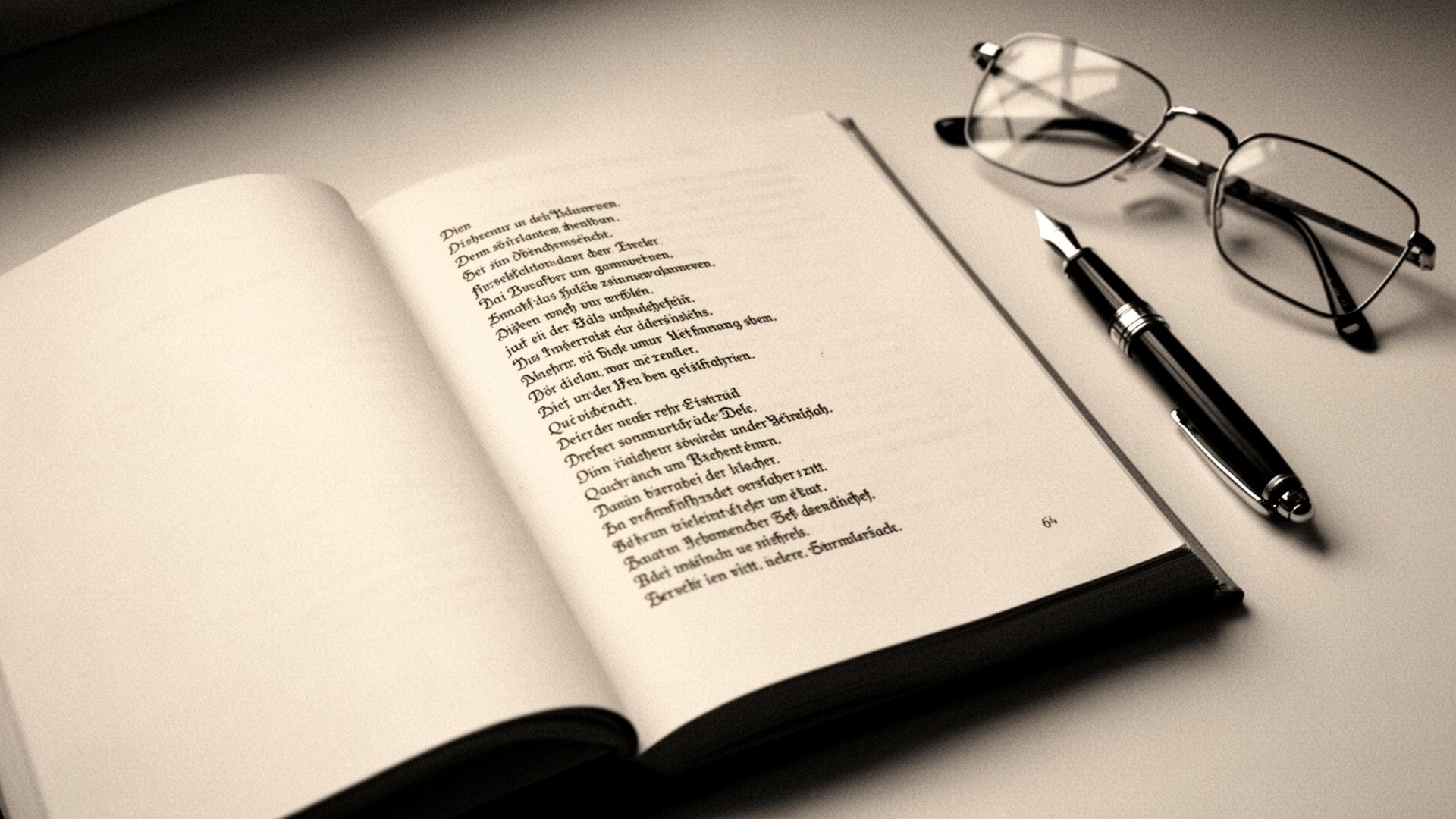 Open German poetry book with fountain pen and reading glasses